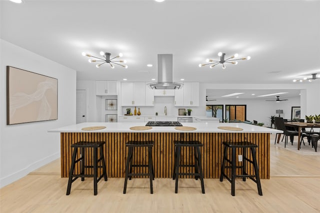1305 Ridgehaven Dr, Austin, TX 78723 - kitchen with a chandelier, island exhaust hood, white cabinets, and light countertops