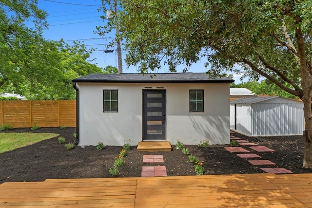 1305 Ridgehaven Dr, Austin, TX 78723 - view of front of home with stucco siding, a deck, and a storage unit
