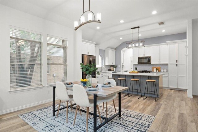 1522 Tamar Ln, Austin, TX 78727 - dining space featuring light wood finished floors, healthy amount of natural light, vaulted ceiling, recessed lighting, and a chandelier