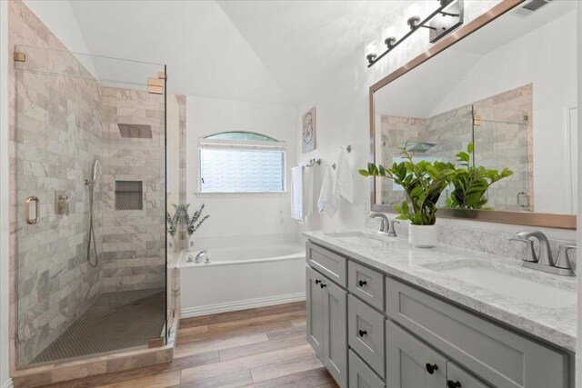 1522 Tamar Ln, Austin, TX 78727 - full bath featuring vaulted ceiling, double vanity, a garden tub, wood finished floors, and a shower stall