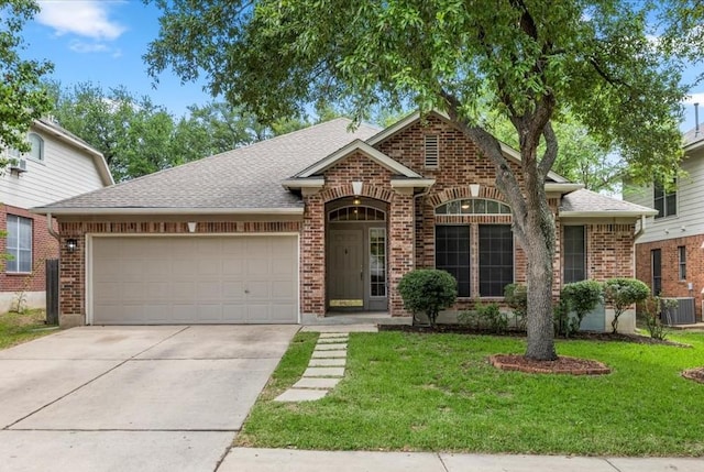 1522 Tamar Ln, Austin, TX 78727 - view of front facade with brick siding, an attached garage, concrete driveway, a front yard, and a shingled roof