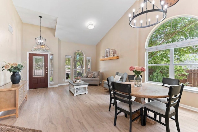 1401 Jackie Robinson Pl, Round Rock, TX 78665 - dining room featuring healthy amount of natural light, a chandelier, high vaulted ceiling, and light wood finished floors