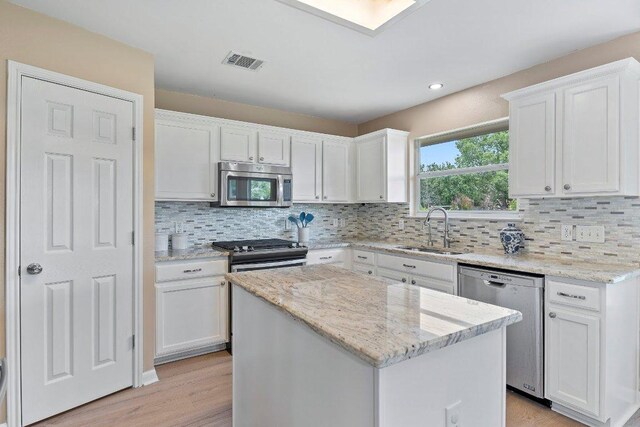 1401 Jackie Robinson Pl, Round Rock, TX 78665 - kitchen with appliances with stainless steel finishes, white cabinets, light wood finished floors, decorative backsplash, and recessed lighting