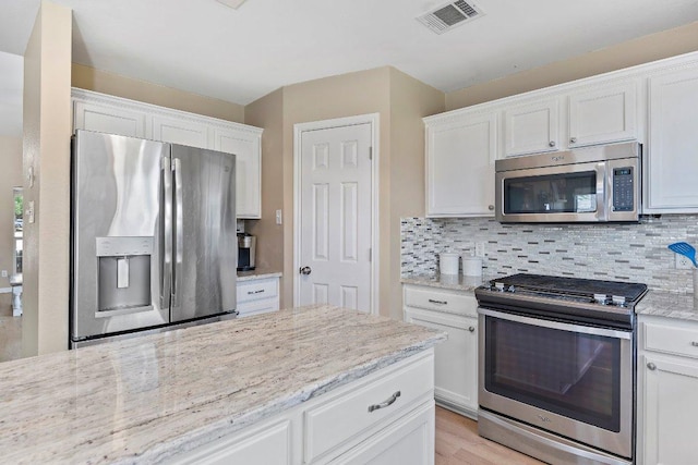1401 Jackie Robinson Pl, Round Rock, TX 78665 - kitchen with stainless steel appliances, white cabinets, and tasteful backsplash