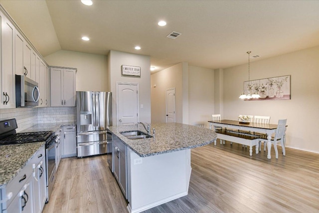 100 Rebel Red Cv, Liberty Hill, TX 78642 - kitchen featuring appliances with stainless steel finishes, a chandelier, light stone countertops, light wood-style floors, and recessed lighting