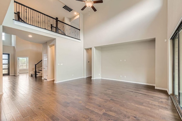 12383 Mesa Verde Dr, Austin, TX 78737 - unfurnished living room featuring a towering ceiling, a ceiling fan, stairway, and dark wood-style flooring