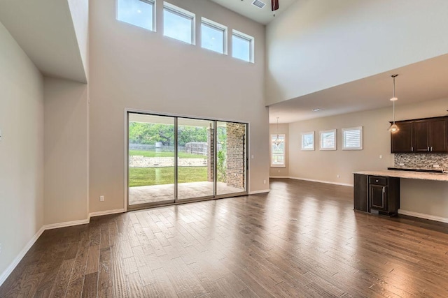 12383 Mesa Verde Dr, Austin, TX 78737 - unfurnished living room with a high ceiling, dark wood-type flooring, and healthy amount of natural light