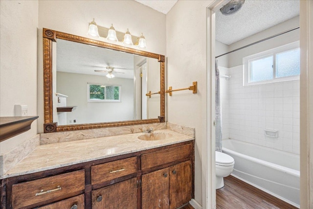 9613 Newberry Dr, Austin, TX 78729 - bathroom featuring vanity, healthy amount of natural light, wood finished floors, bathtub / shower combination, and a textured ceiling