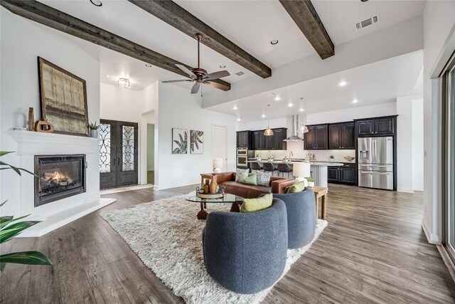 232 Cimarron Hills Trl E, Georgetown, TX 78628 - living room with wood finished floors, beamed ceiling, ceiling fan, a glass covered fireplace, and recessed lighting