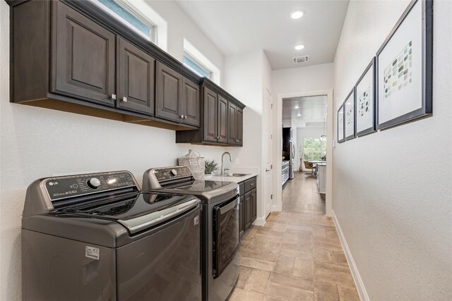 232 Cimarron Hills Trl E, Georgetown, TX 78628 - washroom featuring washer and clothes dryer, cabinet space, light stone finish flooring, and recessed lighting