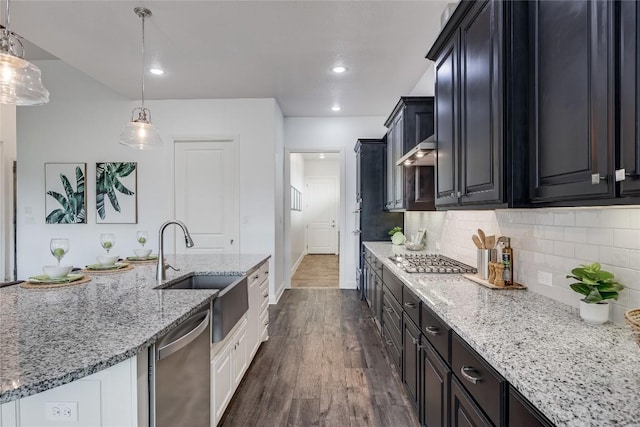232 Cimarron Hills Trl E, Georgetown, TX 78628 - kitchen featuring stainless steel appliances, dark wood-style flooring, decorative backsplash, light stone countertops, and dark cabinetry
