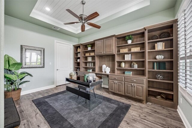 232 Cimarron Hills Trl E, Georgetown, TX 78628 - office area featuring a tray ceiling, wood finished floors, ceiling fan, built in study area, and crown molding