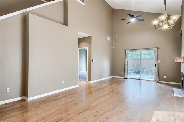 7500 Shadowridge Run Unit 47, Austin, TX 78749 - unfurnished living room with high vaulted ceiling, a ceiling fan, light wood-style floors, a glass covered fireplace, and a chandelier