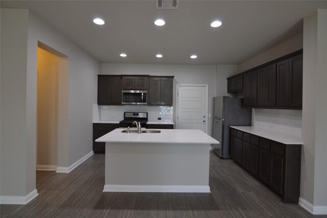 6814 E Riverside Dr Unit 52, Austin, TX 78741 - kitchen with stainless steel appliances, a kitchen island with sink, dark wood-style floors, light countertops, and recessed lighting