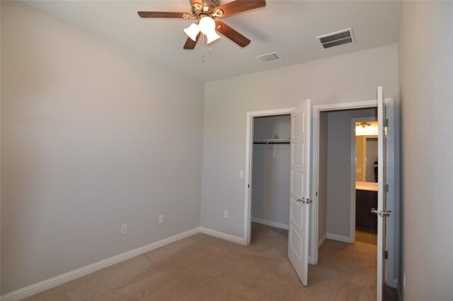 6814 E Riverside Dr Unit 52, Austin, TX 78741 - unfurnished bedroom with light colored carpet, a closet, a walk in closet, and a ceiling fan