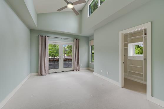 2822 Wooldridge Dr Unit B, Austin, TX 78703 - empty room with ceiling fan, carpet flooring, high vaulted ceiling, and french doors