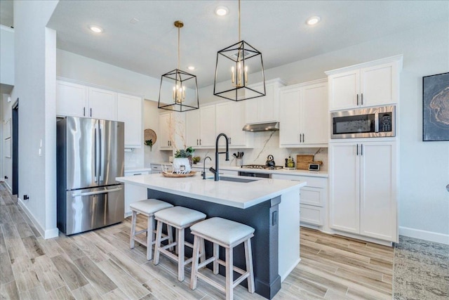 351 Kings Pine Dr, Dripping Springs, TX 78620 - kitchen with stainless steel appliances, light countertops, white cabinets, a chandelier, and recessed lighting