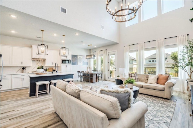 351 Kings Pine Dr, Dripping Springs, TX 78620 - living area with a high ceiling, light wood-type flooring, a chandelier, and recessed lighting