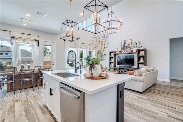 351 Kings Pine Dr, Dripping Springs, TX 78620 - kitchen with stainless steel dishwasher, light wood-type flooring, light countertops, white cabinets, and pendant lighting
