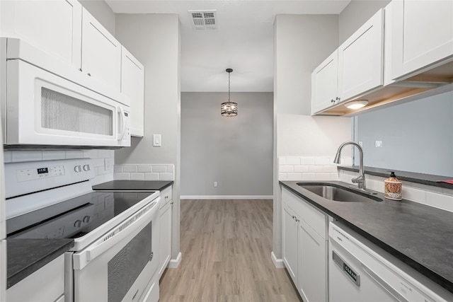 12166 Metric Blvd Unit 2011, Austin, TX 78758 - kitchen featuring white appliances, dark countertops, light wood-style flooring, and white cabinets