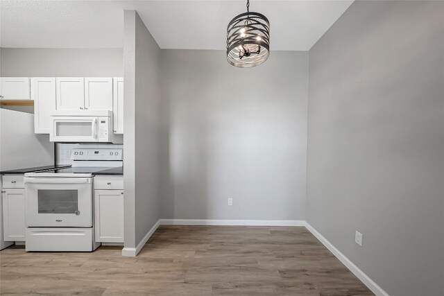12166 Metric Blvd Unit 2011, Austin, TX 78758 - kitchen featuring white appliances, dark countertops, light wood-type flooring, and white cabinetry