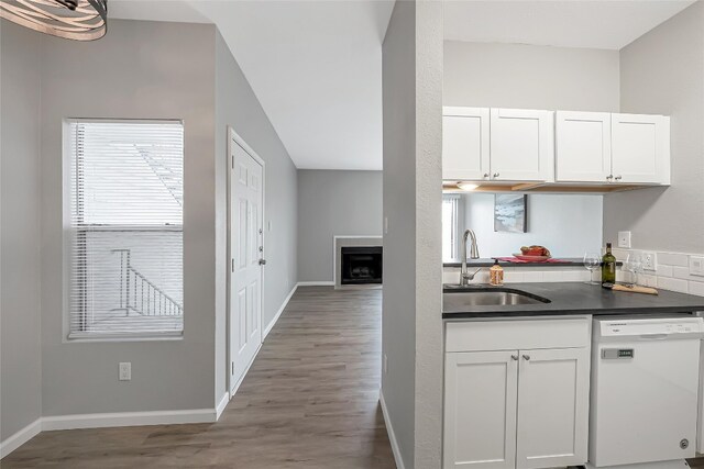 12166 Metric Blvd Unit 2011, Austin, TX 78758 - kitchen with dishwasher, dark countertops, white cabinets, and wood finished floors