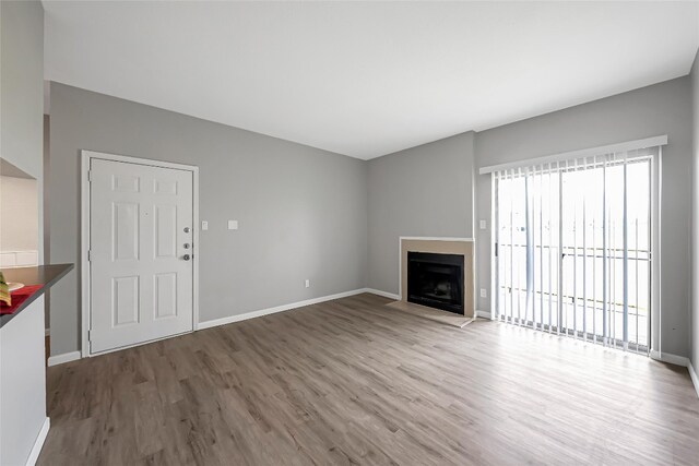 12166 Metric Blvd Unit 2011, Austin, TX 78758 - unfurnished living room featuring wood finished floors and a fireplace with flush hearth