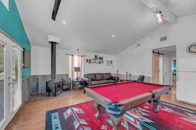 928 Moccasin Trl, La Grange, TX 78945 - game room featuring wood finished floors, a barn door, a wood stove, wainscoting, and an AC wall unit