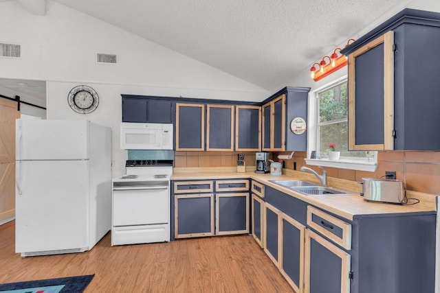 928 Moccasin Trl, La Grange, TX 78945 - kitchen featuring white appliances, lofted ceiling, light wood-type flooring, light countertops, and a textured ceiling
