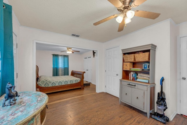 928 Moccasin Trl, La Grange, TX 78945 - bedroom with light wood finished floors, a textured ceiling, a ceiling fan, and crown molding