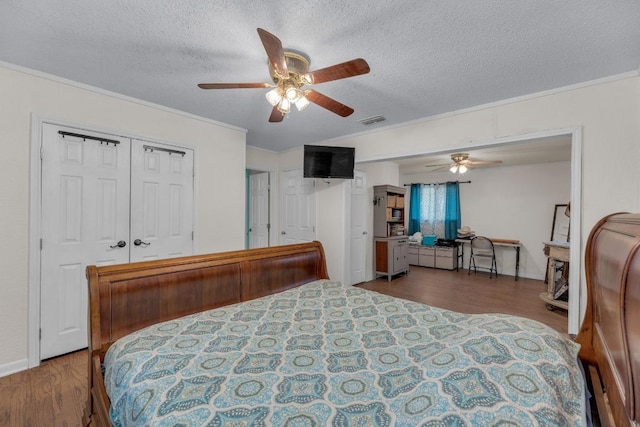 928 Moccasin Trl, La Grange, TX 78945 - bedroom featuring ornamental molding, a textured ceiling, wood finished floors, and ceiling fan