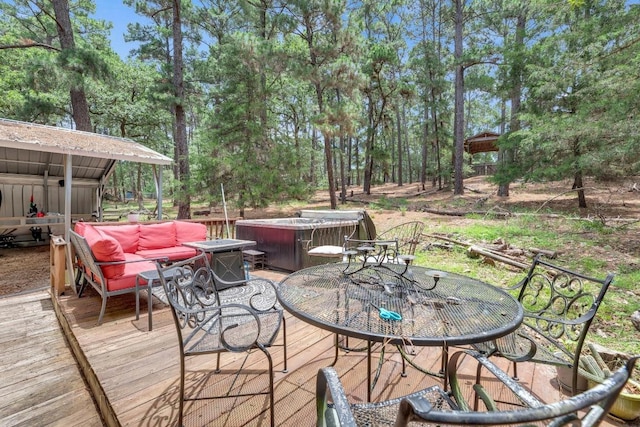 928 Moccasin Trl, La Grange, TX 78945 - wooden deck with outdoor dining area, a hot tub, and view of scattered trees