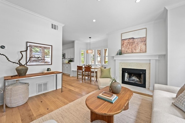 803 Jessie St, Austin, TX 78704 - living room with ornamental molding, recessed lighting, light wood-style floors, and a fireplace