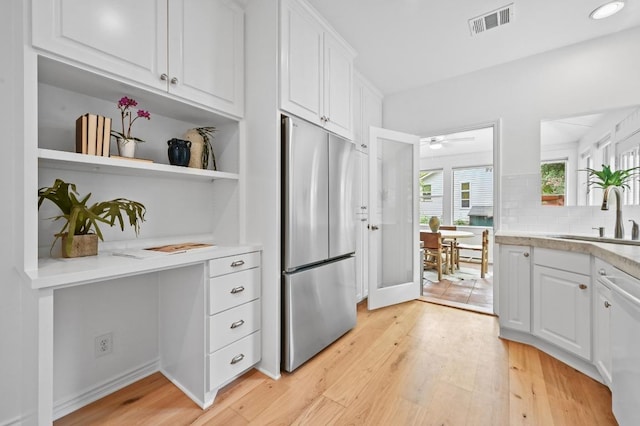 803 Jessie St, Austin, TX 78704 - kitchen with freestanding refrigerator, white cabinetry, light wood-style flooring, and light countertops