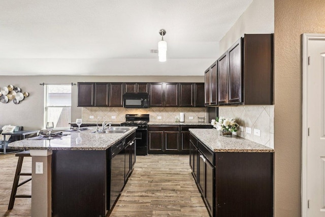 805 Red Tails Dr, Austin, TX 78725 - kitchen featuring black appliances, light wood-style flooring, and dark brown cabinets