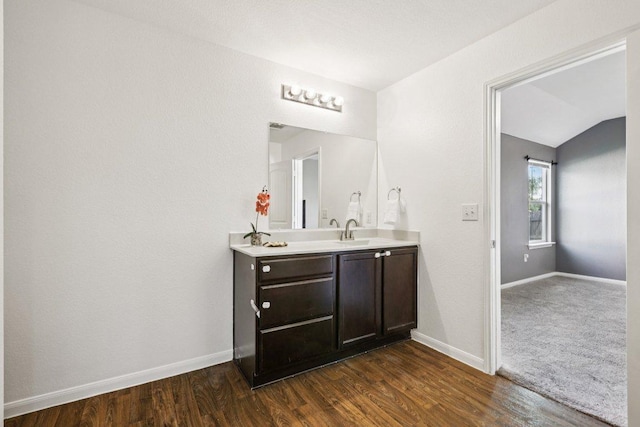 805 Red Tails Dr, Austin, TX 78725 - bathroom with double vanity, wood finished floors, and lofted ceiling
