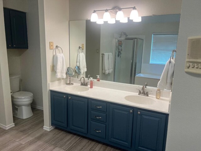 8104 Ephraim Rd, Austin, TX 78717 - bathroom featuring a stall shower, double vanity, wood finished floors, and a bath