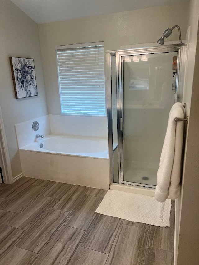 8104 Ephraim Rd, Austin, TX 78717 - bathroom with wood finished floors, a garden tub, and a stall shower