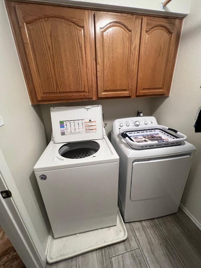 8104 Ephraim Rd, Austin, TX 78717 - laundry room featuring cabinet space, light wood finished floors, and washing machine and clothes dryer