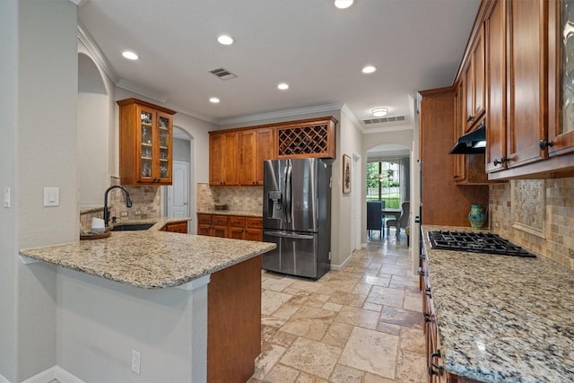 6906 Covered Bridge Dr, Austin, TX 78736 - kitchen with arched walkways, stainless steel refrigerator with ice dispenser, crown molding, brown cabinetry, and a peninsula