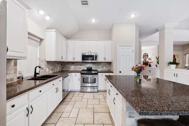 14932 Thatcher Dr, Austin, TX 78717 - kitchen with stainless steel appliances, white cabinetry, stone tile floors, backsplash, and lofted ceiling