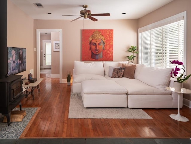 1005 E Riverside Dr, Austin, TX 78704 - living area featuring a ceiling fan, wood-type flooring, and a wood stove
