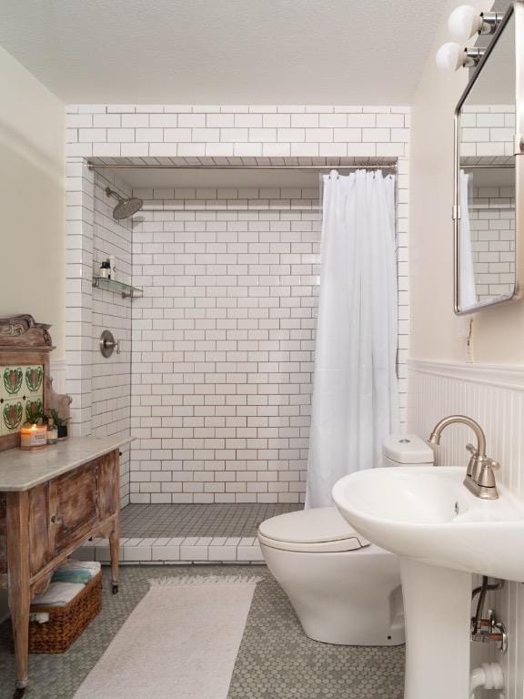 1005 E Riverside Dr, Austin, TX 78704 - full bath with a stall shower, a wainscoted wall, and tile patterned flooring