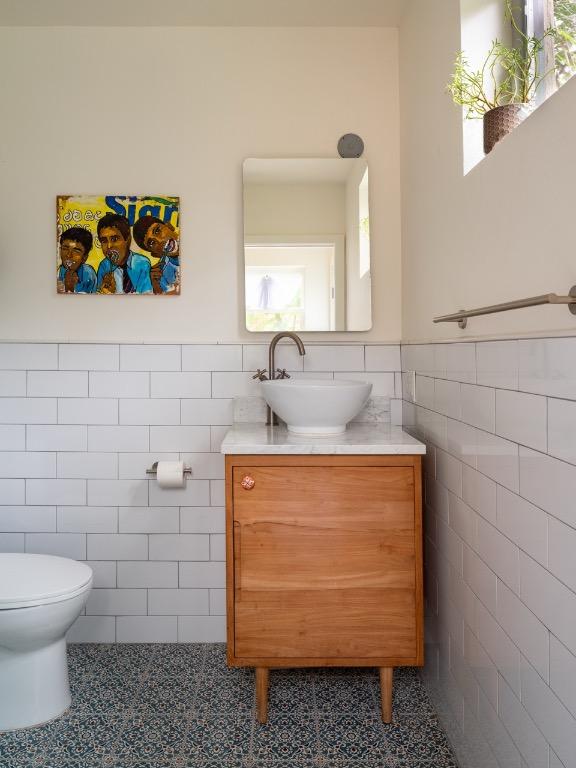 1005 E Riverside Dr, Austin, TX 78704 - half bath featuring tile walls, vanity, tile patterned floors, and a wainscoted wall