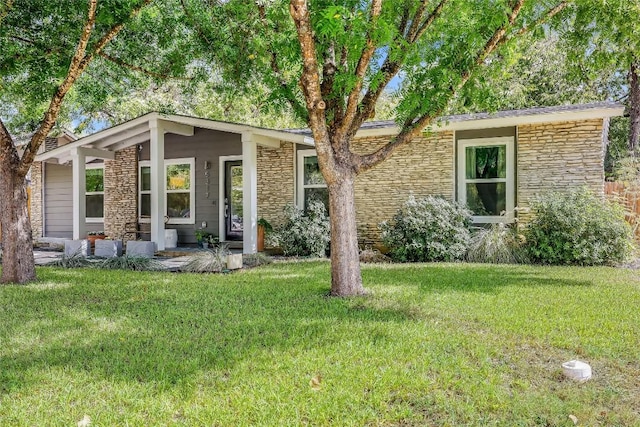 5317 Westminster Dr, Austin, TX 78723 - mid-century inspired home with stone siding, a front yard, and a porch