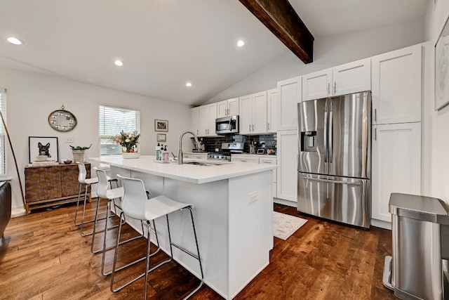5317 Westminster Dr, Austin, TX 78723 - kitchen featuring stainless steel appliances, a kitchen breakfast bar, dark wood-type flooring, a center island with sink, and recessed lighting