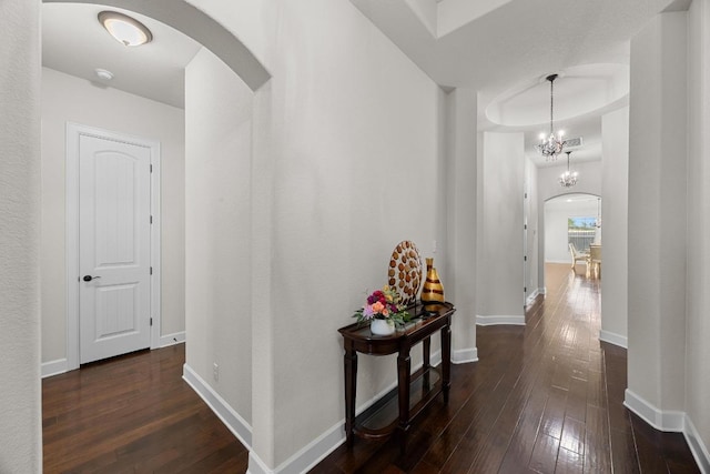 509 Fair Oaks Dr, Georgetown, TX 78628 - hallway with arched walkways, dark wood-type flooring, and a chandelier