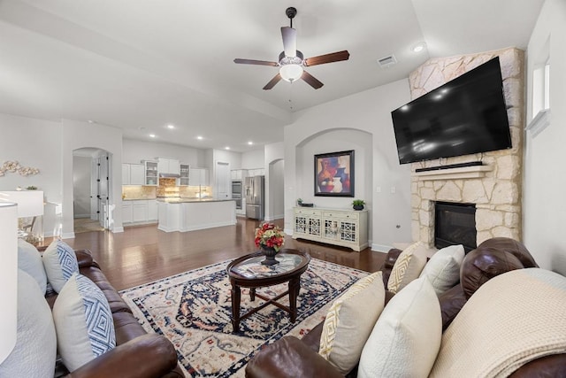 509 Fair Oaks Dr, Georgetown, TX 78628 - living area with arched walkways, a ceiling fan, wood finished floors, a fireplace, and recessed lighting