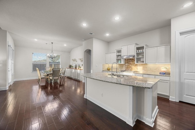 509 Fair Oaks Dr, Georgetown, TX 78628 - kitchen with white cabinetry, light stone countertops, backsplash, dark wood-style floors, and a kitchen island with sink