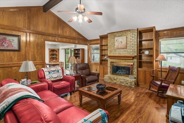 1601 Samoa Ct, Pflugerville, TX 78660 - living room featuring a ceiling fan, wood finished floors, wood walls, healthy amount of natural light, and a brick fireplace